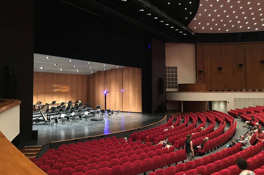 Console grandMA3 light en situation dans une régie, connectée à un réseau d'éclairage de scène de théâtre.