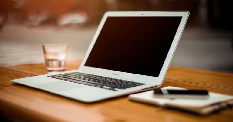 Console DMX professionnelle de type grandMA3 sur une table de régie, écrans allumés affichant une programmation d'effets lumi