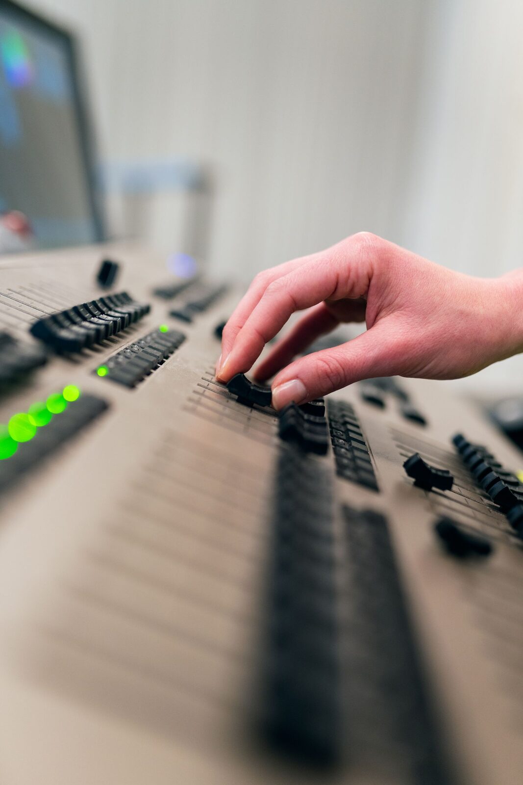 Doigts sur les faders d'une console d'éclairage